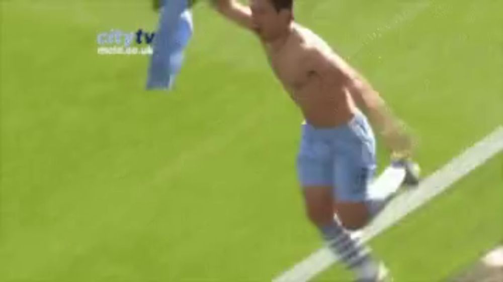 a shirtless soccer player is running on the field with a flag in his hand