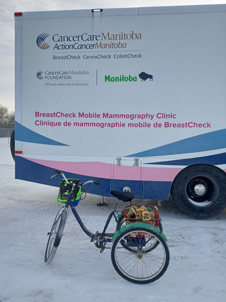 Cute etrike with bright green fenders in front of huge mobile mammogram clinic unit