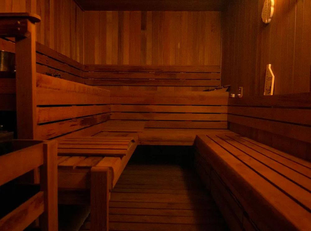 A wooden planked steam room. It’s all bare, brown wood. You know how in Star Trek the Next Generation there’d be a crazy landscape with five moons, viking ships with warp engines, psychic frog merchants, waterfalls that go up, and asteroids that sing and then someone would say “end program” and the shot would turn into a black room with yellow lines? Someone turned the program off in this room.