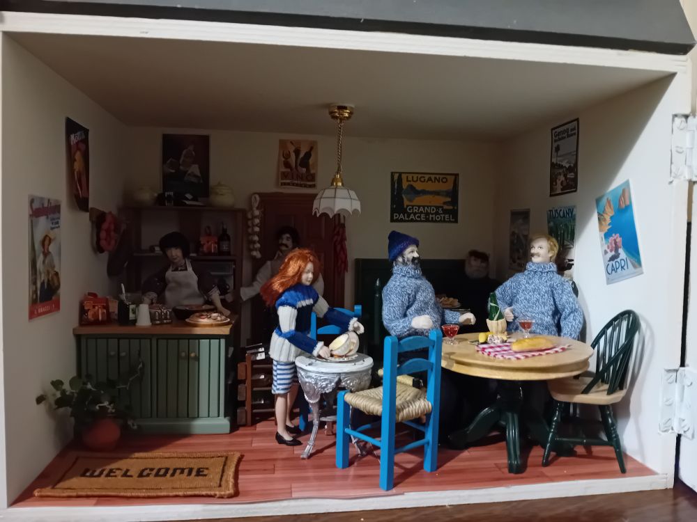 A dollshouse restaurant - on the ground floor the locals are eating bread and cheese with wine. A teenager is clearing tables.