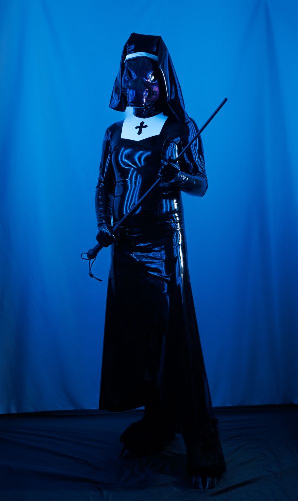 Purple shiny pony person holding a sjamobk and wearing a latex nun habit