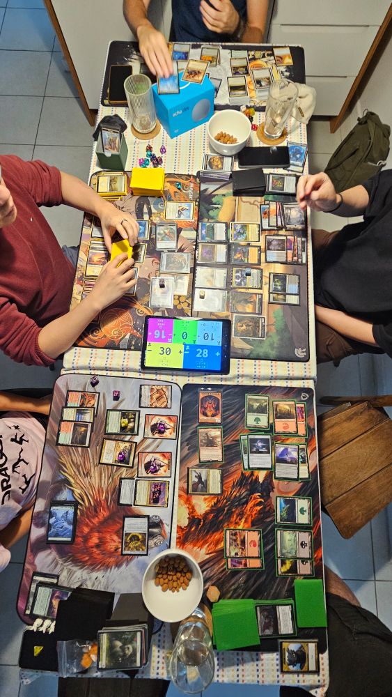 Foto da mesa com 5 pessoas jogando commander, modo de jogo do jogo Magic The Gathering