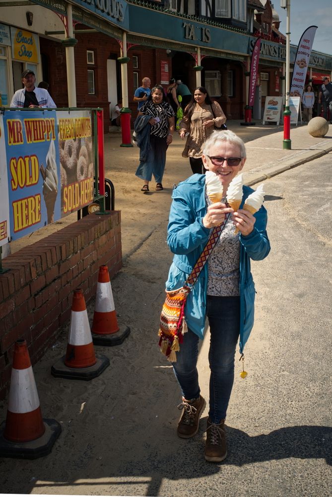 Street Portrait of a very happy woman holding three ice-cream cones on a sunny afternoon. 