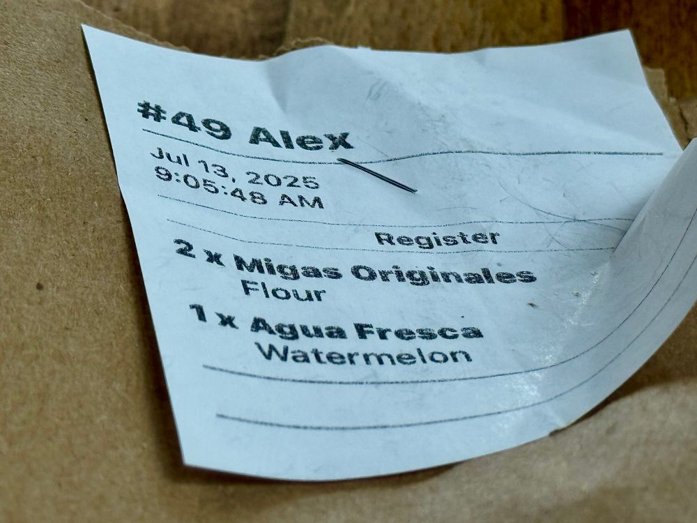 A receipt from vera cruz all natural for two migas tacos and a watermelon aqua fresca.