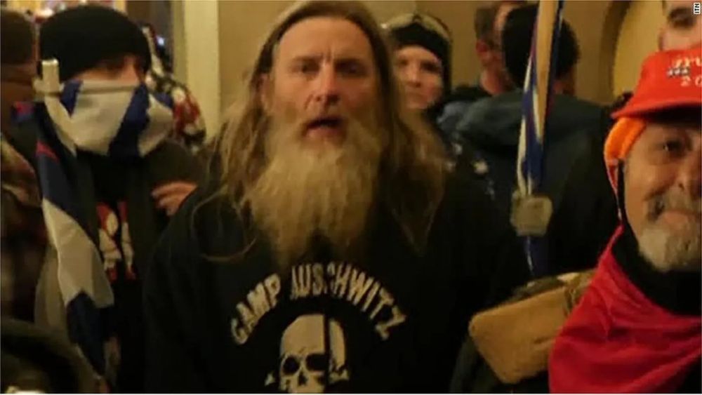 Pardoned January 6th rioter wearing sweatshirt emblazoned with "Camp Auschwitz."