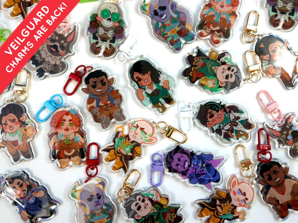 A photo showing some of my Dragon Age Veilguard double sided acrylic charms featuring all of the companions plus Manfred, Assan, and Solas