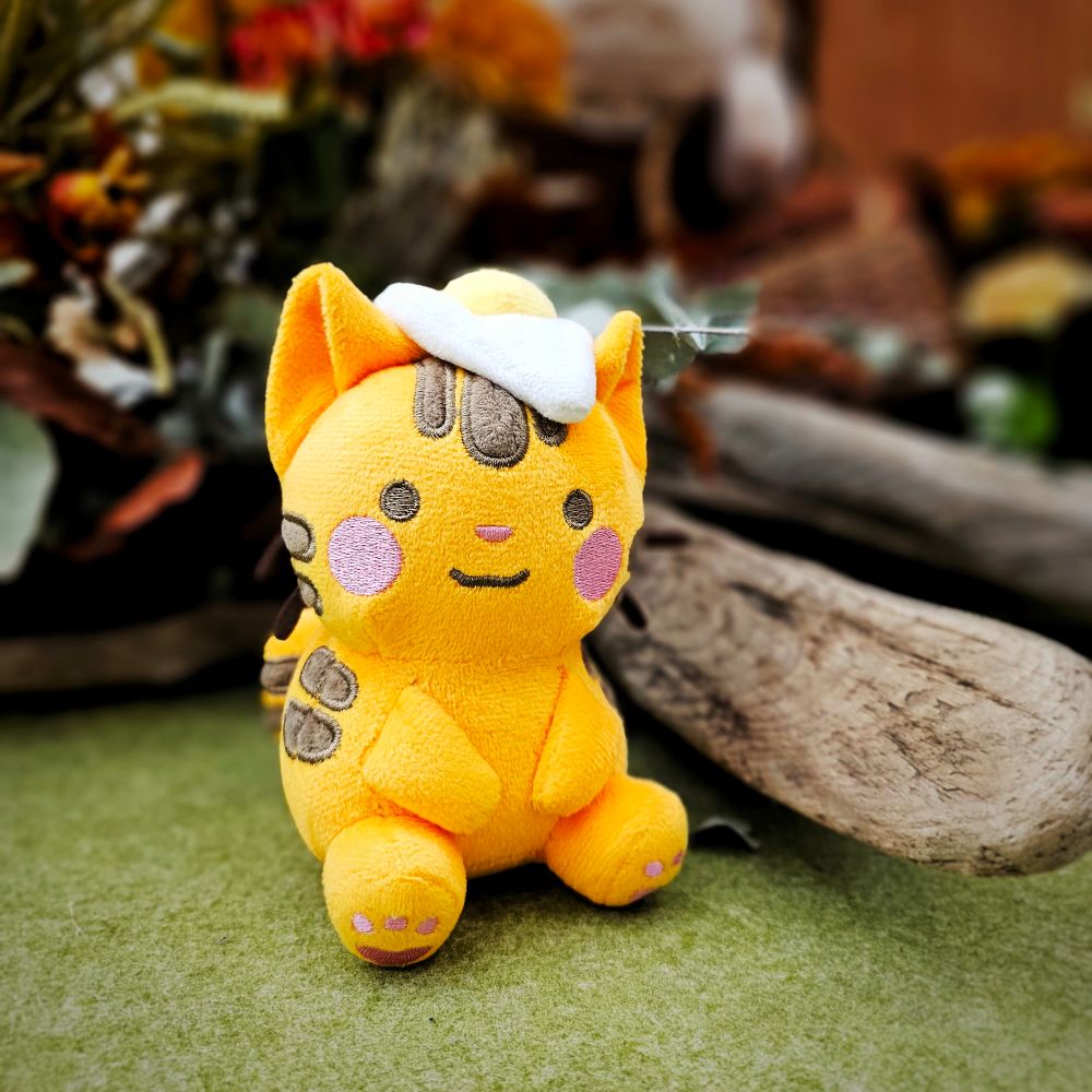 A plushie of an orange cat with a egg on its head