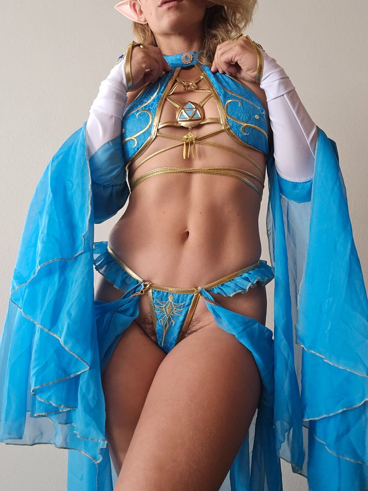 A faceless photo of me wearing blue and gold lingerie. Flowing fabric drapes across my body. 