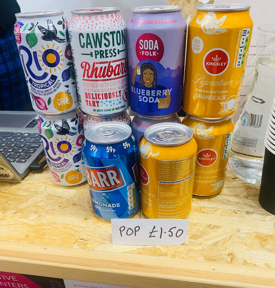 a stack of fizzy drink xmas with the sign “pop £1.50”