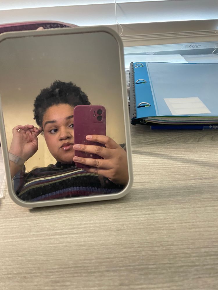 Another mirror selfie of myself wearing a striped turtleneck and holding a burgundy phone case