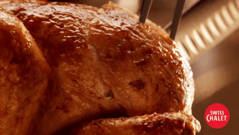 a close up of a roasted chicken with swiss chalet in the corner