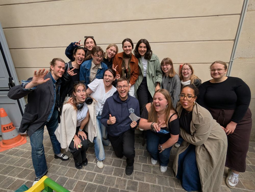A bunch of cool people doing a "silly photo" next to the university trashcans