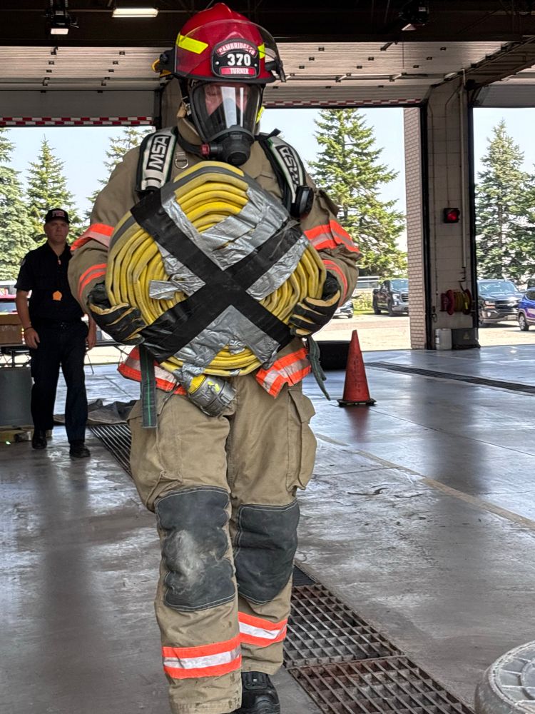 A fire chief in full turnout gear, including a self-contained breathing apparatus (SCBA), actively participating in an air consumption drill. 
