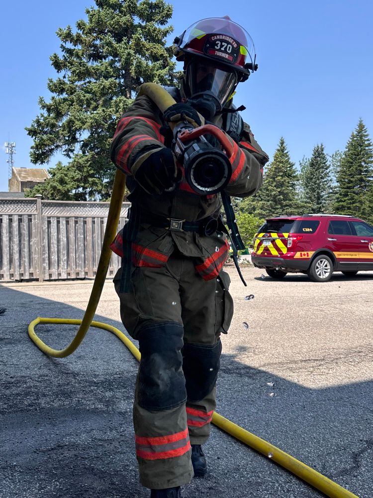 A fire chief in full turnout gear, including a self-contained breathing apparatus (SCBA), actively participating in an air consumption drill. 
