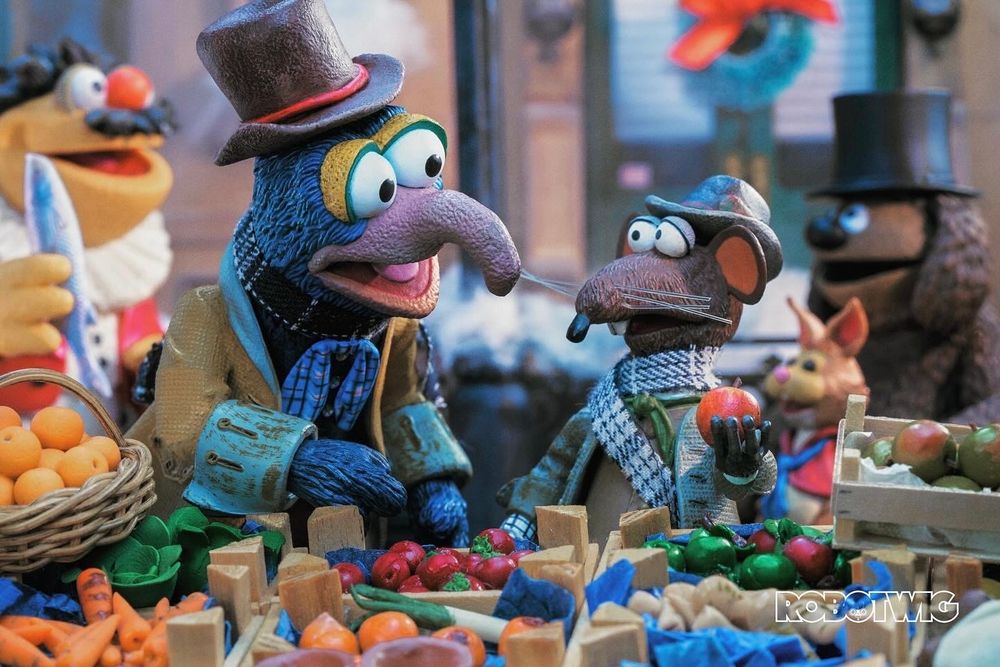 Gonzo and Rizzo stand at a fruit and veg stall in the middle of a busy Victorian street 