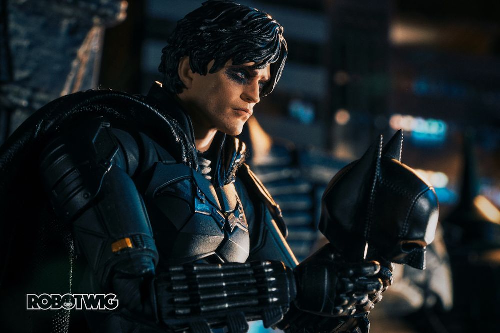 Batman sits unmasked looking down on the city of Gotham