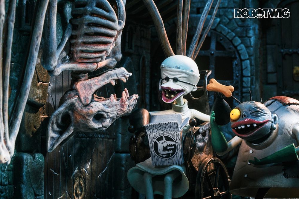 Finkelstein holds up a dog biscuit for a skeleton pet bat he has in his dungeon, Egor stands next to Finkelstein hoping to have a biscuit too