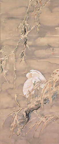 two egrets standing close together near center of image; snow covered branch hangs down from UR; snow-covered branches and foliage in foreground LR
In Japanese art, herons/egrets are often depicted in pairs, amid willow trees and reeds. In this lyrical scene, the birds’ bright plumage, crisply delineated in opaque white pigment, stands out against the gloomy ink wash of the background. Withering foliage appears to bow beneath the weight of settling snow, cleverly suggested by unpainted space.