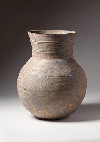 bulbous, round bottomed jar with flaring neck and wide mouth; five bands of wavy incised lines, and five incised ribbed bands