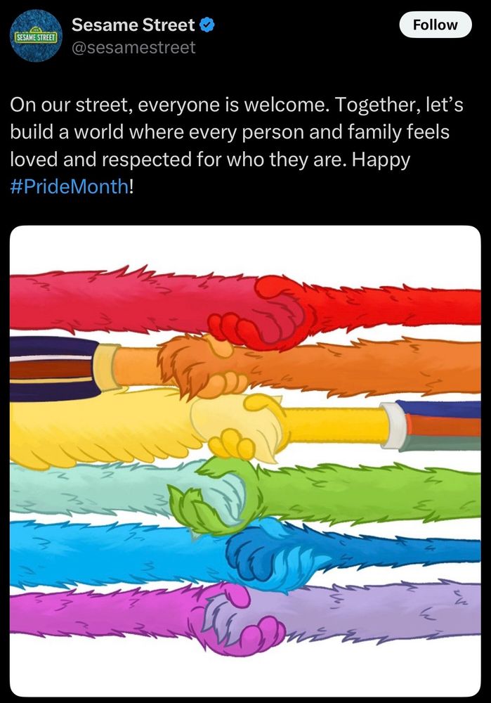 All the colors of Sesame Street characters arms holdimg one another.