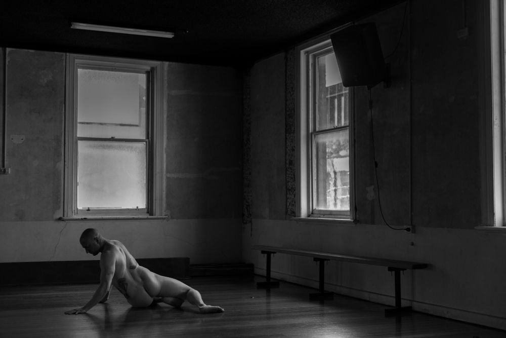 Male model on floor, twisting left, head left of frame