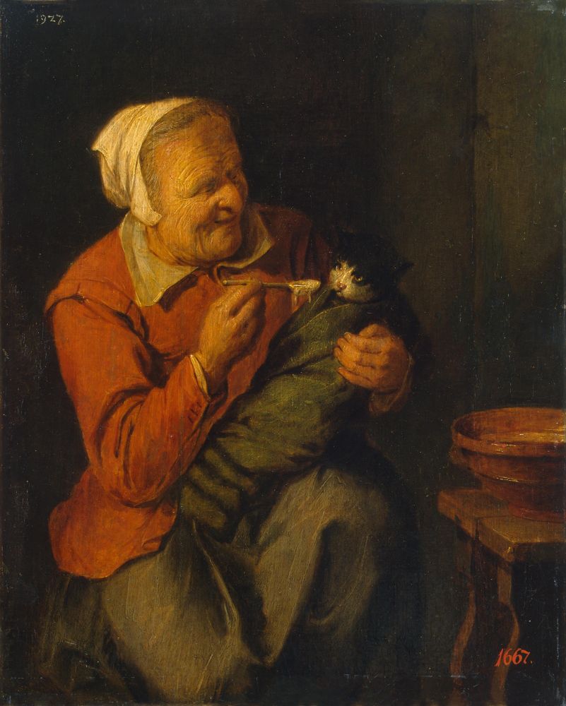 A painting of an older white woman in a white kerchief and red doublet feeds a black and white cat with a spoon. The cat is wrapped up in a green blanket on her lap
