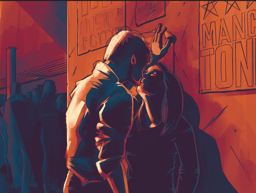 A couple kissing in a club bathed in orange light.