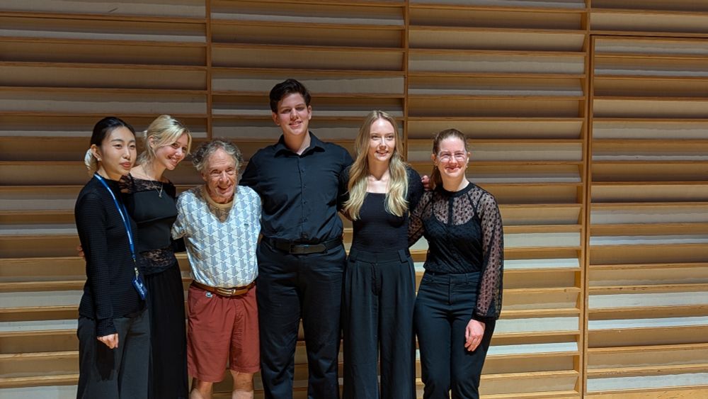 Elliot and five people pose for a photo on stage