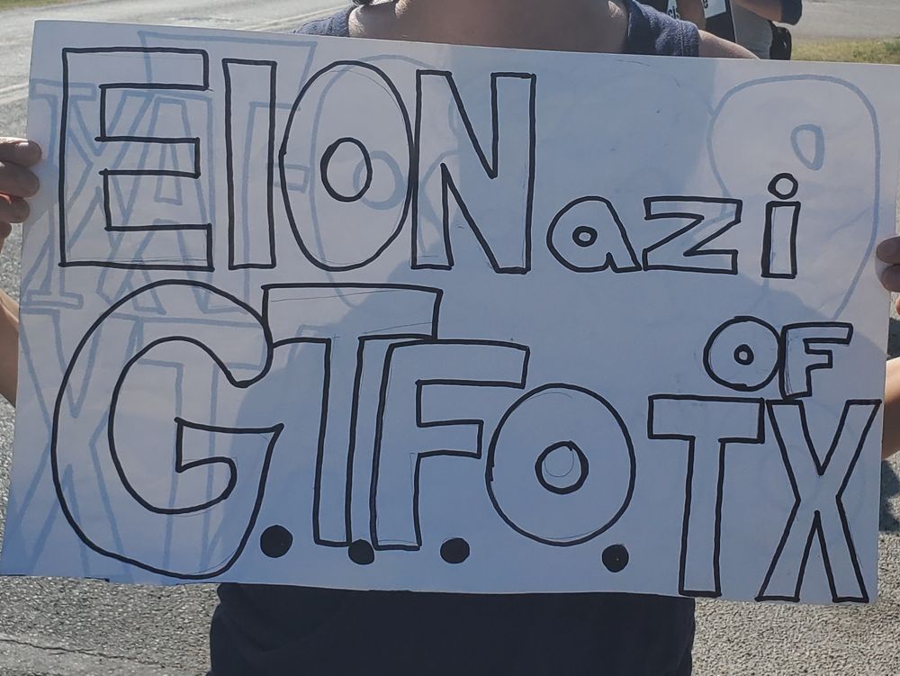 Tesla Takedown protest sign: ELONazi G.T.F.O. OF TX