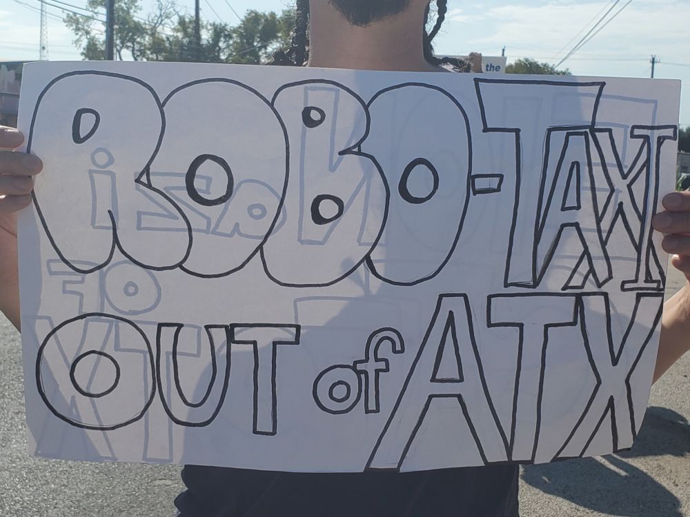 Tesla Takedown protest sign: ROBO-TAXI OUT of ATX
