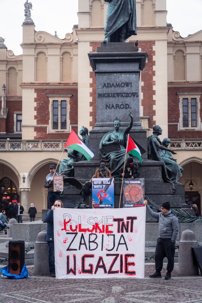 Zdjęcie z demonstracji 29 listopada 2025 roku w Krakowie. Baner z napisem "Polskie TNT zabija w Gazie". Pomnik Adama Mickiewicza. 