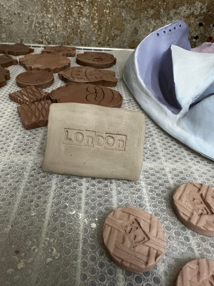 A trifold name plate is made out of clay and has not been glazed yet. 
