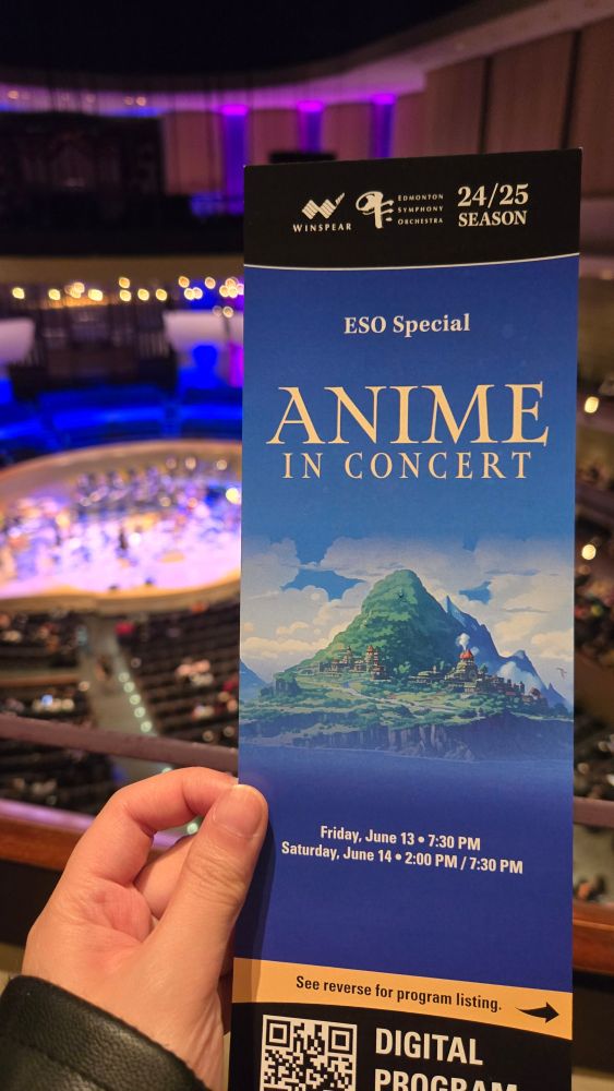 Anime in Concert pamphlet in the forefront with the concert stage in the backdrop 