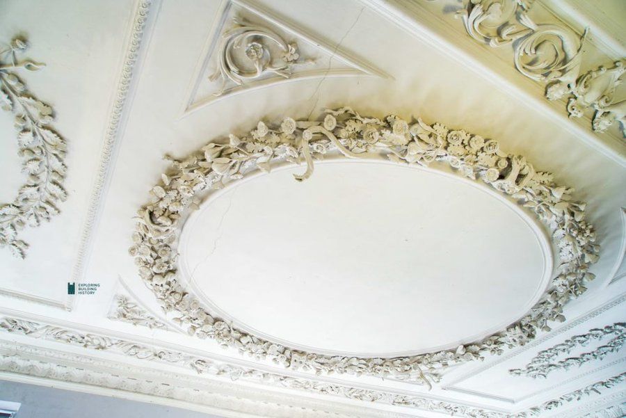 Photograph of the ceiling plaster in the Long Room at the Exeter Quay, The whole of the ceiling is white, and in the center there is what looks like a wreath done in white plaster. The wreath has flowers, and leaves, and -- YES! -- eels. It's worth considering that this kind of wreath only works as sculpture, or relief, or some other similar thing. A real wreath with leaves and flowers and eels would be a bit gruesome, and would smell badly. It would look a bit like a very ambitious shrike had been at work.

This assumes, of course that the eels are dead. If they are alive, hanging out in a holiday wreath on someone's door, then you should probably assume that they have been ensorcelled, and you should probably leave what is clearly the house of a great eel wizard. You don't want any truck with that kind of trouble.

FTR, ensorcelled is a great word. It sounds a bit like the feeling of twisted, swirly candy rolling around your mouth.