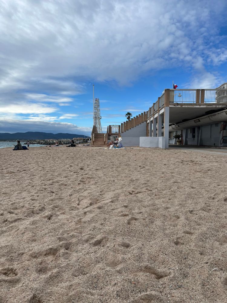 An einem leeren Strand, im Hintergrund ein Riesenrad.
