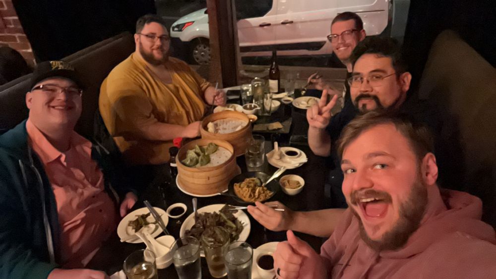 Five large gentlemen beginning their quest to conquer a mountain of dumplings, sake, and beer