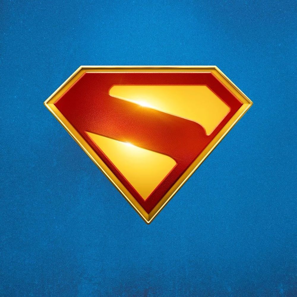Red and yellow Superman logo (stylized red ‘s’ on a yellow diamond shape) on a blue background.  