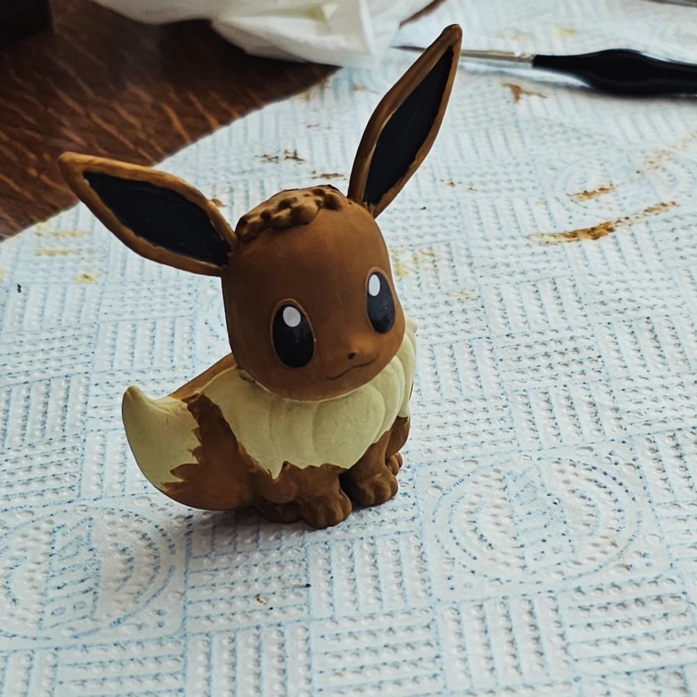 A painted statue of the pokemon Eevee in a sitting position.