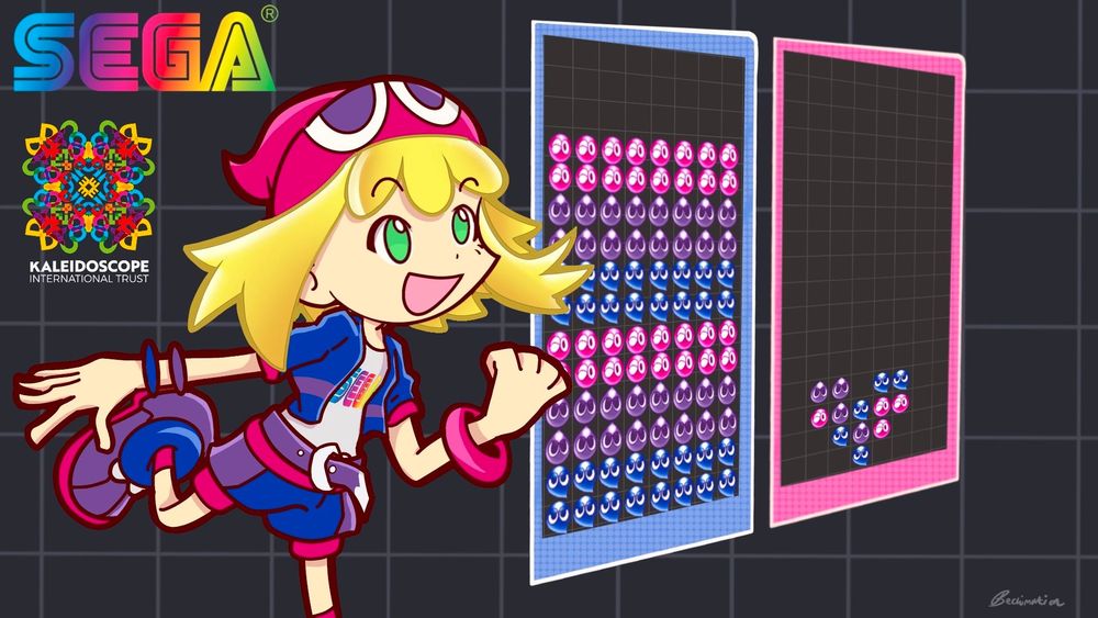 Amitie, a girl dressed in the colours pink, purple and blue, has a determined/excited expression on her face as she looks over two puyo puyo game boards. The boards in question feature puyo's (small blob like creatures) all stacked up in the colours of the bisexuality flag (pink, purple and blue.) 