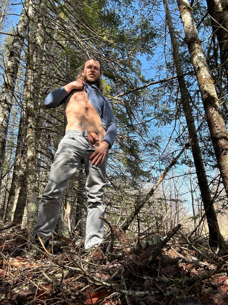 Jake is flashing some skin in a forest. 