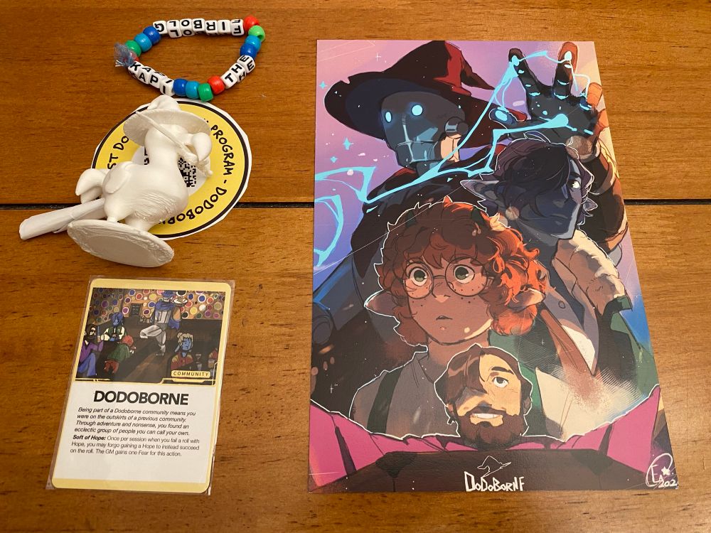 Swag for the dodoborne actual play podcast, including a friendship bracelet, dodo figurine, card, and mini poster
