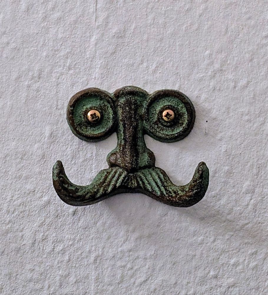 Coat hook shaped like a curly moustache