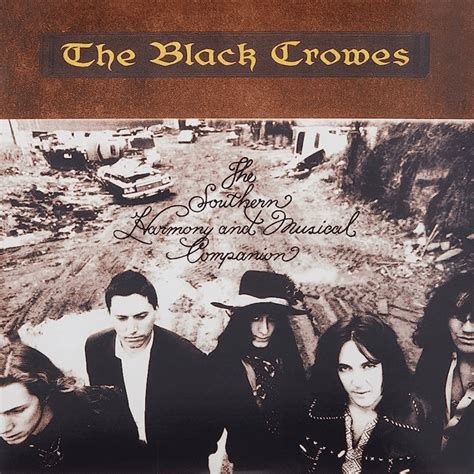 Album cover for The Southern Harmony and Musical Companion by The Black Crowes, featuring a sepia-toned photograph of the band members standing in a desolate, rubble-strewn street with old cars in the background. The band name appears at the top in yellow Gothic lettering on a brown banner, and the album title is written in ornate script across the centre.