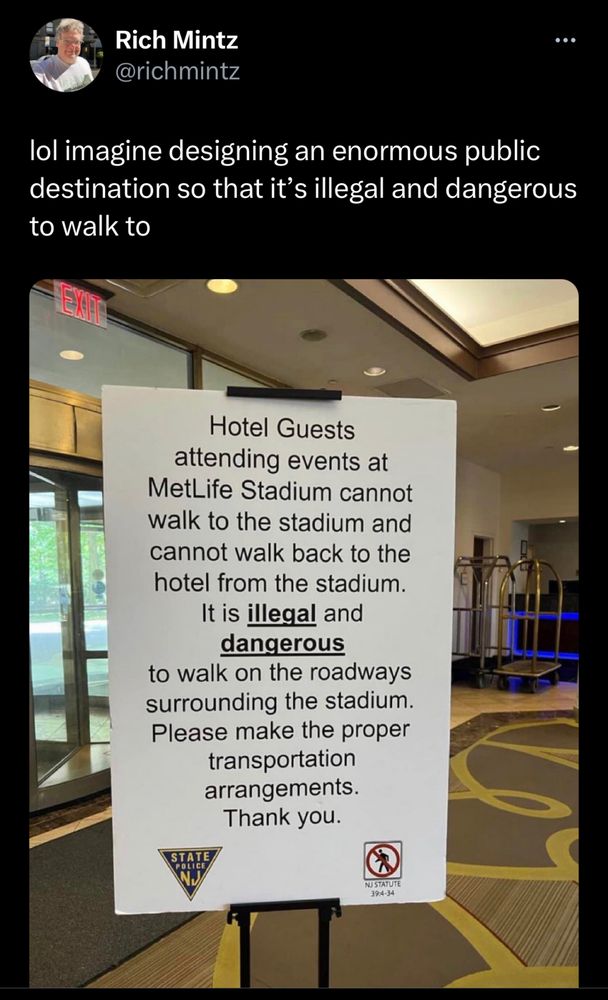 Tweet that reads: Rich Mintz @richmintz
lol imagine designing an enormous public destination so that it's illegal and dangerous to walk to

Sign in the tweet: Hotel Guests attending events at
MetLife Stadium cannot walk to the stadium and cannot walk back to the hotel from the stadium.
It is illegal and dangerous
to walk on the roadways surrounding the stadium.
Please make the proper transportation arrangements.
Thank you.