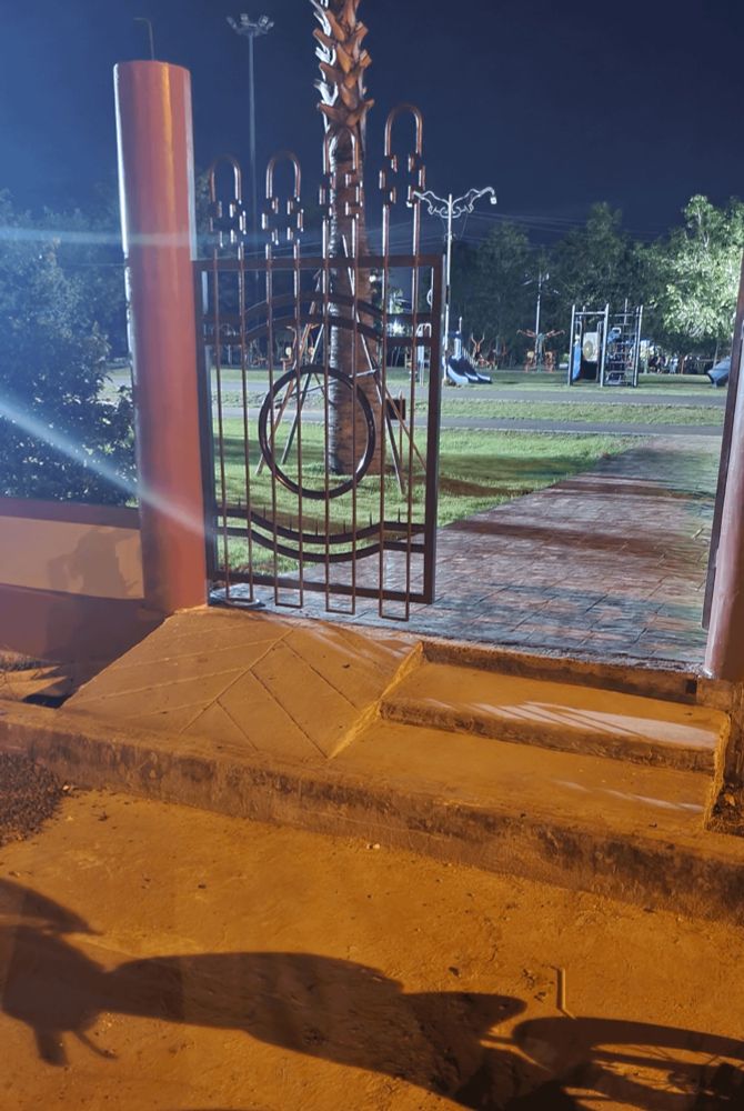 a wheelchair ramp at an entrance to a park that ends at a high curb before dropping off