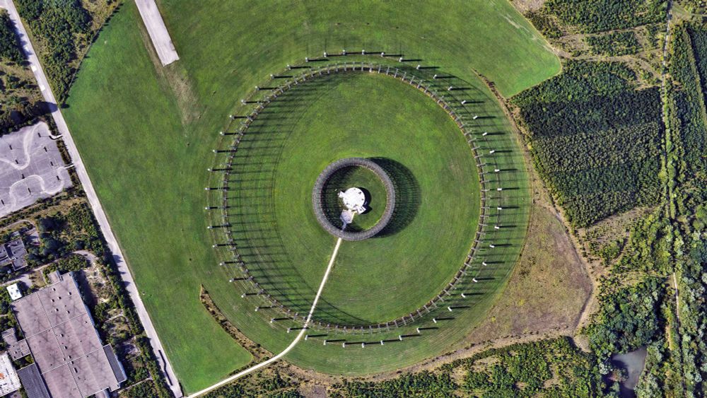 United States Army Security Agency (USASA) Field Station Augsburg - West Germany 

the picture is showing a green field of grass on which a big circular antennae structure is visible, in its center, another circular structure is present
