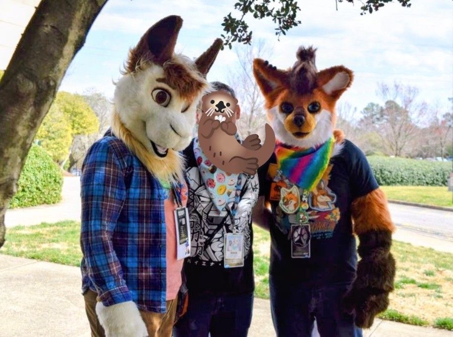 Alpaca and maned wolf fursuiter on either side of a cute otter dude