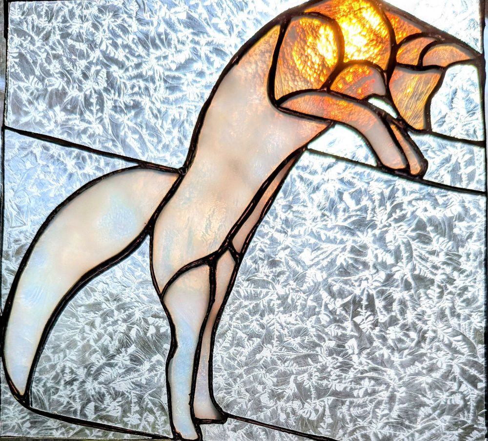 Stained glass arctic fox jumping against a background of frosted white glass