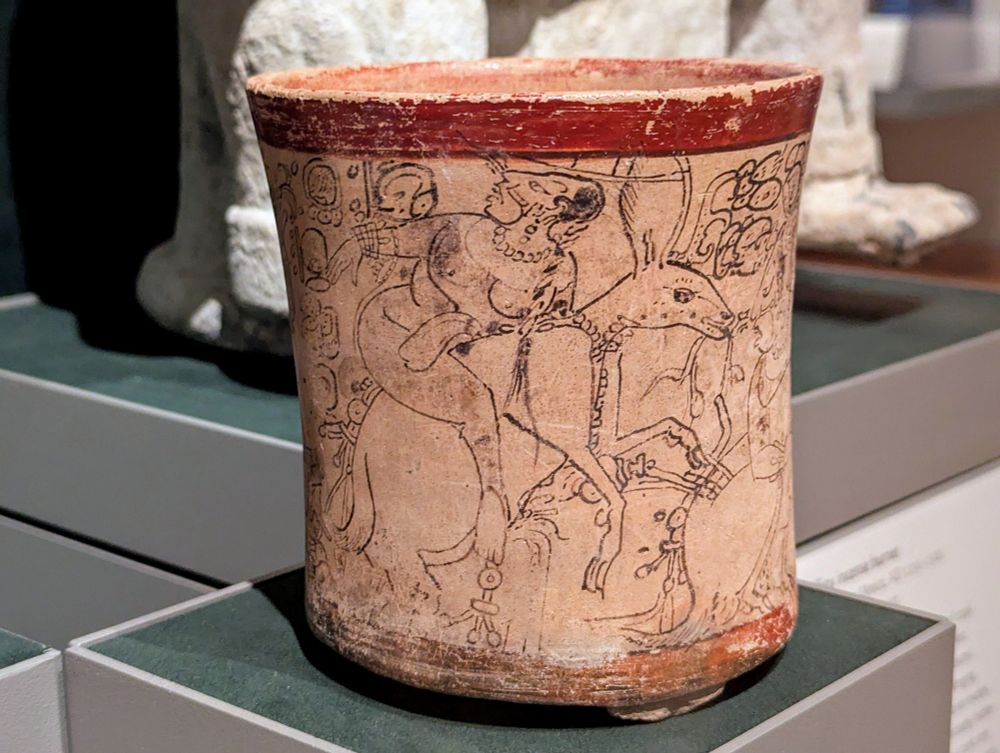 Ceramic vase with red rim and bottom and lineart illustrations in black 