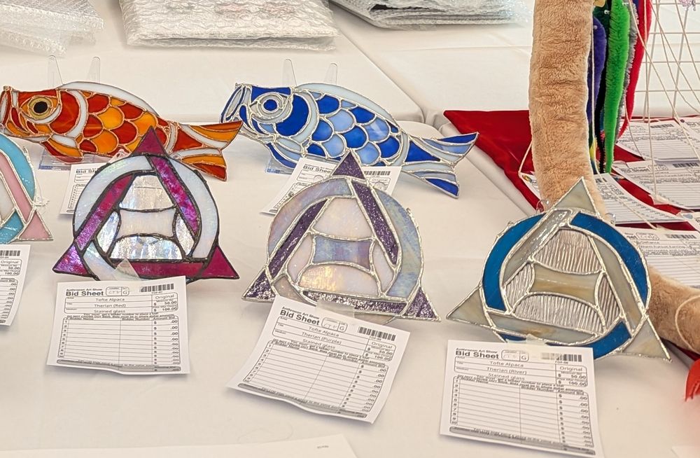 Three therian theta deltas, one red, white, and transparent iridescent; one white and purple; one blue and sand with rippled clear glass